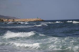 bay of villaricos, rough sea, beach, village and mountains at the background photo