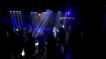 blurred silhouettes of a crowd of dancing people on the dance floor at a live music concert video