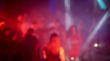 blurred silhouettes of a crowd of people dancing on the dance floor in a nightclub video