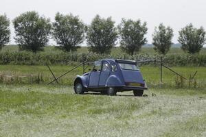 old car drives on grassland photo