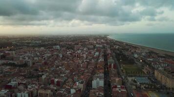 varrendo aéreo Visão do costeiro cidade às crepúsculo debaixo ninhada nuvens video