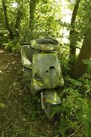 scooter abandoned in a forest photo
