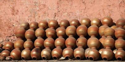 handmade pottery dries against a wall, jaipur, india photo