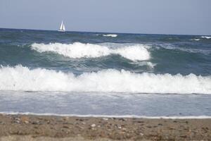 velero a mar, olas en el costa foto