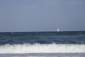 sailboat at sea, waves on the coast photo