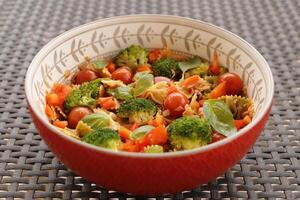 pasta with broccoli, cherry tomatoes, tuna fish, basil, bell pepper photo