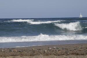 sailboat at sea, waves on the coast photo