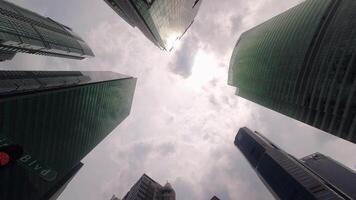 enfocar en centro de deportes acuáticos bulevar firmar y pov cámara Derecho arriba mediante moderno rascacielos edificios con azul cielo. pov ver de ciudad horizonte edificios moderno negocio distrito video