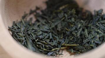 Extreme Close up of Dry Green Tea Leaves are Filling in Small Bowl video