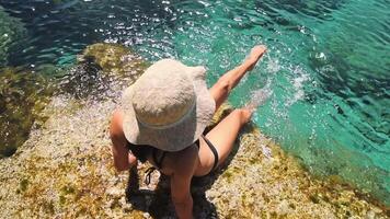 Beautiful caucasian woman sit on viewpoint rock enjoy crystal clear waters and mediterranean seascape panorama on summer holiday vacation. Happiness and travel explore concept video