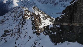 Aerial view of Cheget mountain range in snow sunny clear weather video