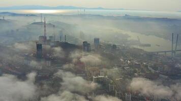 das mystisch Morgen Stadt mit Häuser verhüllt im Nebel. golden Brücke video