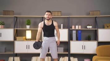 Bodybuilder exercising with dumbbells at home. video