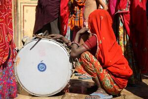 indian woman hiding face behind orange clothes, sari photo