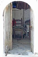 view through an old door in an old house on a chair, crete, greece photo