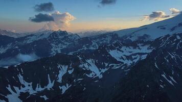 Aerial view beautiful enticing snowy mountains amid cloudy sky Beauty of enticing snowy mountains haven for mountain rest. Enticing snowy mountains where Earth's aesthetics peak nature beauty. video