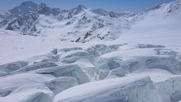 A massive iceberg amidst snowy mountain landscape under a freezing sky video