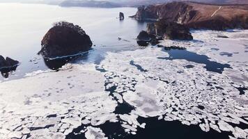 settentrionale della natura bellezza fusione ghiaccio nel oceano rigido contrasto per aspro scogliere fusione ghiaccio simboleggia delicato ambientale equilibrio danza di natura. fusione ghiaccio avvolgente settentrionale scogliere. video