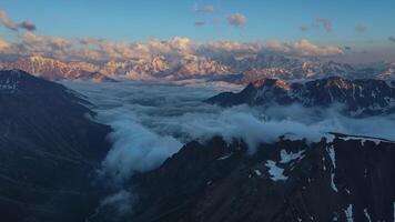 tentador Nevado montañas encapotado en nublado cielo susurro de primitivo maravillas en medio de tentador Nevado montañas encontrar serenidad del Norte esplendor. paisaje corazón tentador Nevado montañas hipnotiza. video