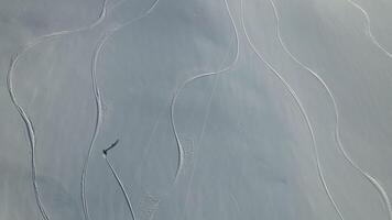 Skier glides down slope surrounded by snowy peaks Skier in harmony with vast untouched northern landscape. Skier capturing essence of winter's magnificence Dance with snow journey through wilderness. video