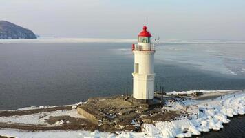 Aerial view of the lighthouse in winter in the ice at dawn video