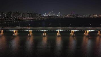 panoramico aereo Visualizza di Seoul han fiume a notte luccichii sotto città luci han fiume a notte vena attraverso metropoli riflette di seoul polso. lungo han fiume a notte di seoul cultura maestà svelare. video