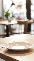 An empty plate on a wooden table in a restaurant. photo