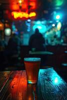 A lonely beer sits on a wooden table in a bar, waiting to be drunk. photo