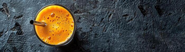Glass of fresh carrot juice on a dark background. photo