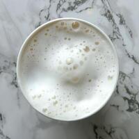 An overhead view of a cup of coffee with milk on a marble table. photo