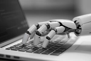 A black and white photo of a robot typing on a laptop.