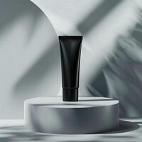 A black tube of face cream on a white podium against a white background with shadows. photo