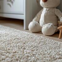 A close up of a white fluffy rug on a wooden floor next to a stuffed animal. photo