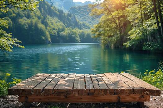 An empty wooden dock on a lake surrounded by trees and mountains photo
