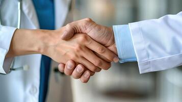 Two doctors in white coats shaking hands photo