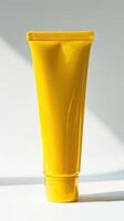 A yellow plastic tube of sunscreen on a white background photo