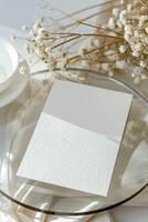 Blank paper card mockup on the glass plate with dry twigs. photo