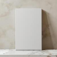 A minimal mockup of a blank vertical canvas frame standing on a marble shelf against a beige textured wall. photo