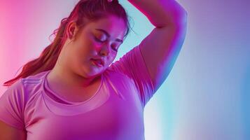 Confident, beautiful, plus size woman posing in pink shirt on bright neon blue and pink background. photo