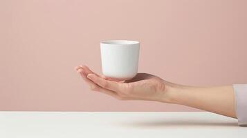 sostener un taza con uno mano limpiar escritorio en contra un minimalista y de color claro fondo foto