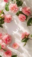 A white table with a bunch of pink camellias on the table photo