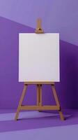 An easel with a white canvas on a stretcher stands in a clean purple blue room photo