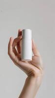 closeup of woman s hand holding a white roll on deodorant bottle photo