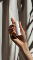 closeup of woman s hand holding a white roll on deodorant bottle photo