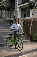 A happy, carefree Asian businessman going to work with his bicycle on a sunny day. photo