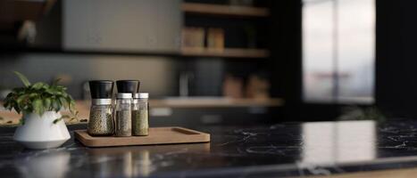 A set of spice bottles on a luxury black marble kitchen countertop in a modern black kitchen. photo