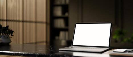 A modern home office workspace with a white-screen laptop mockup on a black marble table. photo