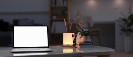 A laptop mockup, a table lamp, and accessories on a coffee table in a modern room at night. photo