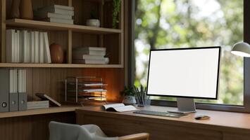 A computer mockup on a wooden desk against the window in a modern and comfortable home office. photo