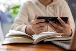 A cropped shot features a woman in a white hoodie using her smartphone, watching online s photo